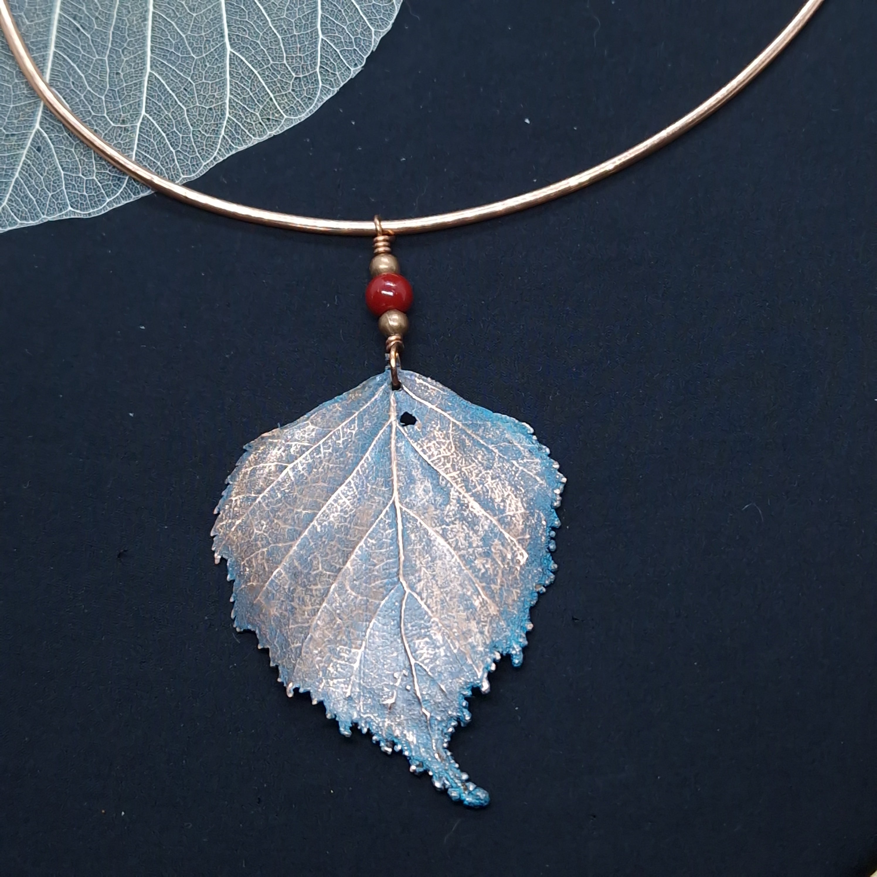 Torque de cobre electroformado con hoja de aliso, acabado azul verdoso y bolita roja